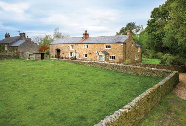A long country lodge in North Yorkshire overlooking a walled paddock lined by trees