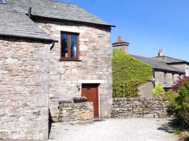 Exterior of a stone built cottage overlooking a courtyard.