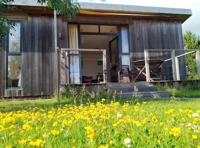 Decked entrance, outdoor dining area and meadow setting.