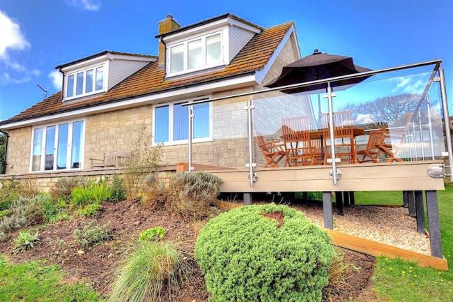 A large multi-windowed chalet bungalow in Charmouth with an extended plate-glass walled deck
