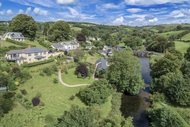 Aerial view of an Exmoor river valley overlooked by village cottages.