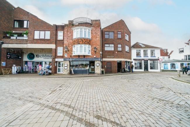 A row of contemporary shops with two floors of apartments above.