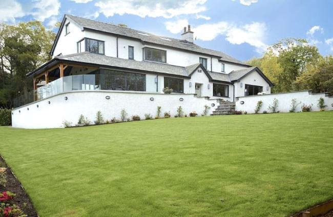 Large Windermere holiday cottage on a terrace overlooking a spacious lawn.