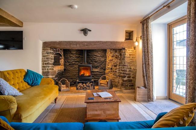 A lounge with twin sofas, inglenook fireplace and French windows.