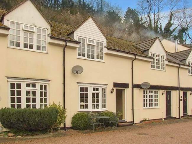 Exterior of a large cottage with 4 first-floor dormer windows.