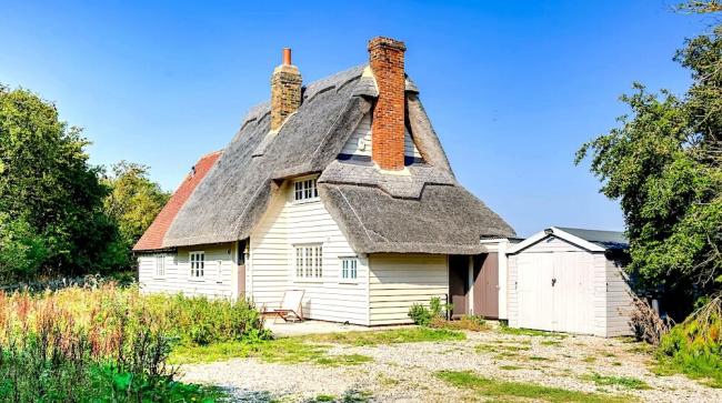 A clapperboard thatched holiday cottage and garden in Essex.