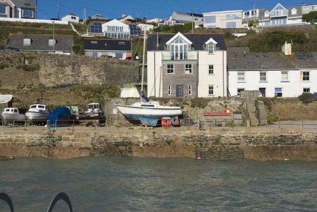 Waterfront terrace overlooks a harbour with small boats stored on the Quay.