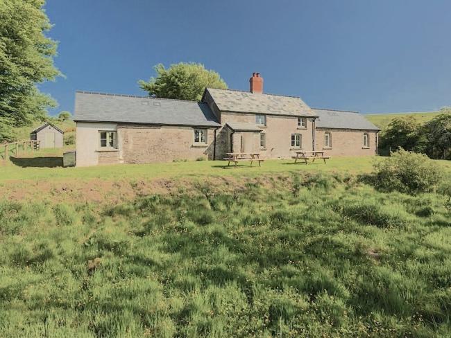 The exterior of a stone-built Exmoor farmhouse in a remote moorland location.