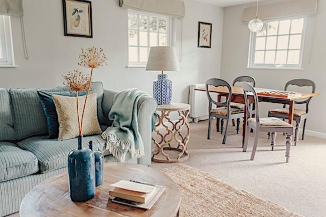 Lounge diner with cushion-covered sofa, two. coffee tables and dining table and chairs for 4.