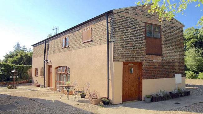 Exterior of a Cambridgeshire, brick built barn conversion in a courtyard.