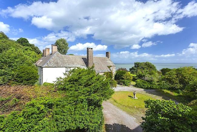 A stone-built country cottage for couples overlooks a large and sunny lawn.