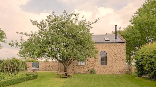 A Somerset barn conversion, partially obscured by a tree.