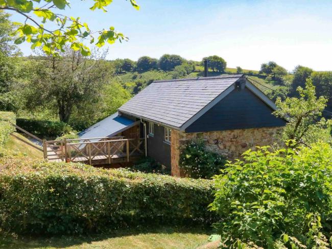 A single-storey, stone-built, luxury Exmoor barn conversion surrounded by trees and hedgerows.