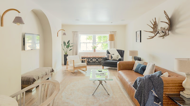 A luxuriously-furnished lounge with a wide-screen TV and a large leather sofa.
