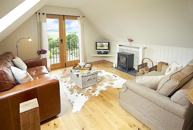  A lounge with comfortable seating and rural views in a luxury loft apartment.