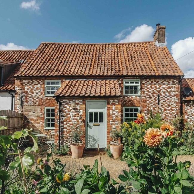 An ornate brick-built detached Kings Lynn holiday cottage overlooking a flower-filled garden. 