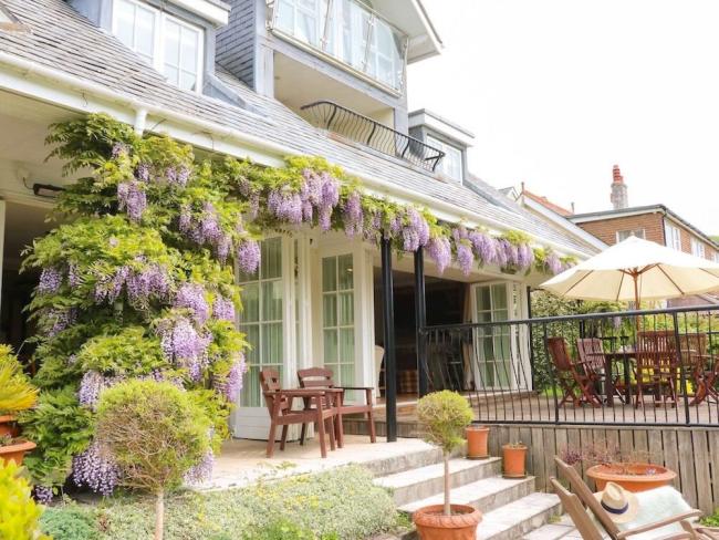 Wisteria-clad exterior of a Luxury waterside holiday home.