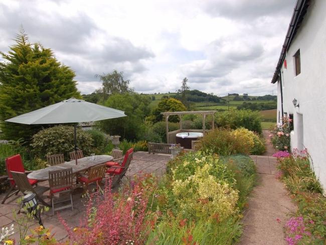 A flower-filled garden with rural views alongside a Somerset holiday cottage. 