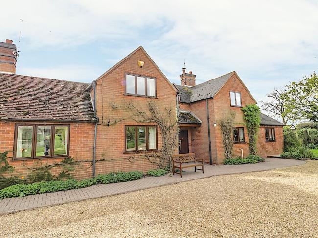 A twin-gabled brick holiay home overlooking a guest car-parking area