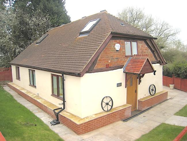 2-storey chalet bungalow surrounded by a garden.