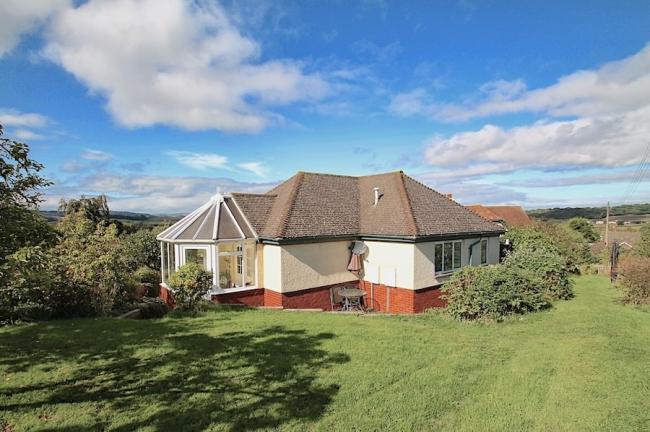 A bungalow surrounded by lawns and open countryside on the West Somerset coast..