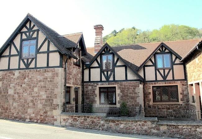 A 2-storey stone-built house overlooks a courtyard.