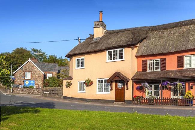 A thatched holiday cottage faces the village green in Exford.
