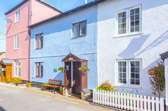 A 2-storey coastal cottage in Watchet with a gabled porch opening onto a village street.