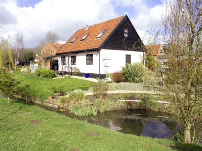 A Norfolk barn conversion overlooks a riverside lawn.