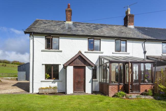 Semi-detached Exmoor country cottage with conservatory and lawned garden.