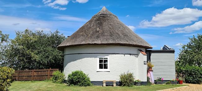 Circular exterior of cottage created within the base of a Suffolk windmill.