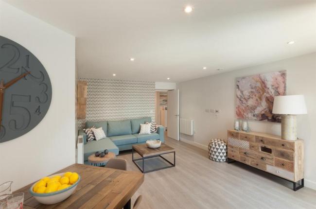 Spacious seaside apartment lounge with sofa, coffee table and sideboard.