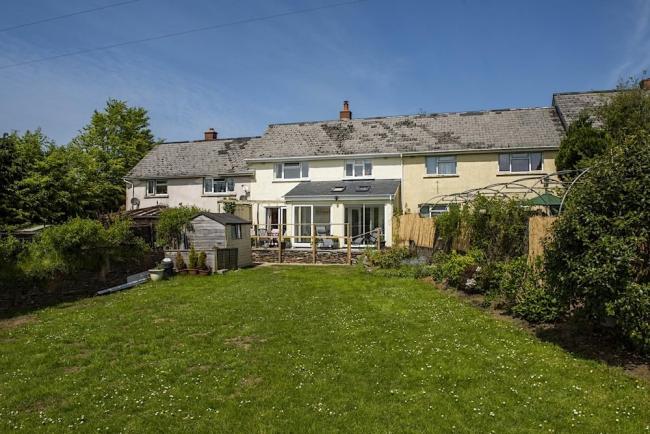 A one-bedroom, modern terraced holiday cottage with a large rear lawn.