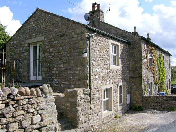 A 2-storey, end-of-terrace stone-built holiday cottage in Settle with a walled side garden.