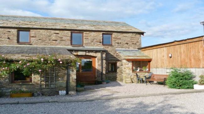 An extended 2-storey Scottish barn conversion with one wall lined by roses