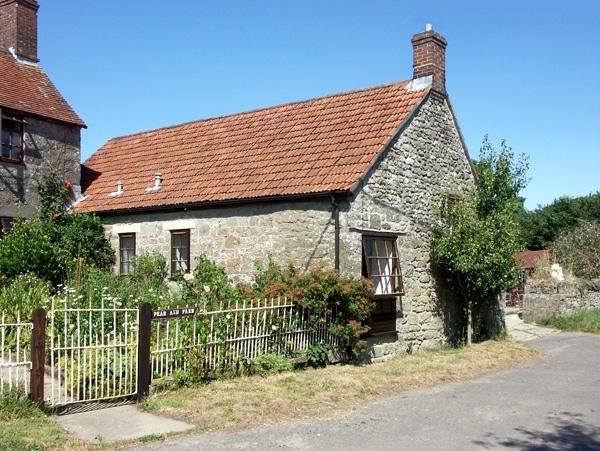 A stone-built somesret holiday cottage with a mature garden overlooks a quiet lane.