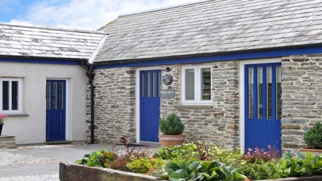An L-shaped, single-storey barn conversion overlooks a courtyard and a raised flowerbed.