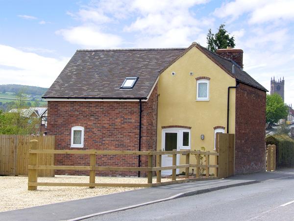 A 2-storey holiday cottage has generous off-road parking outside the front door and a garden behind.