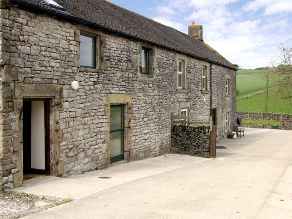 A stone-built country cottage overlooks a large courtyard