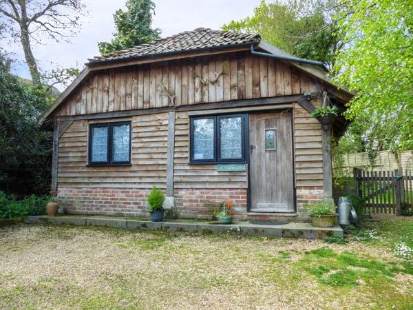 Exterior of a wooden eco-lodge near Ringwood backed by mature trees.