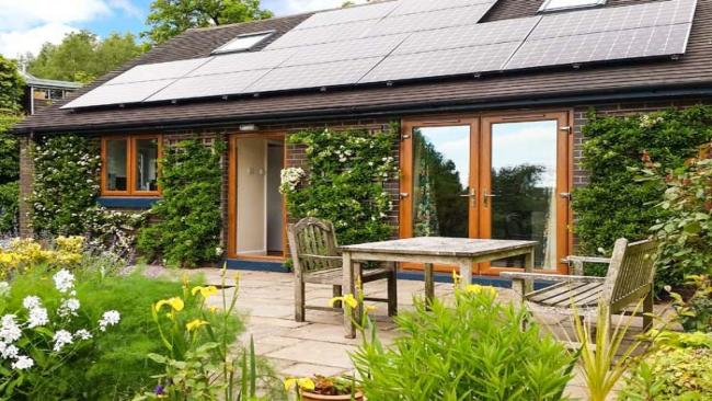 A contemporary Staffordshire Holiday cottage with floor-to-ceiling French windows overlooks a terrace and flower garden.