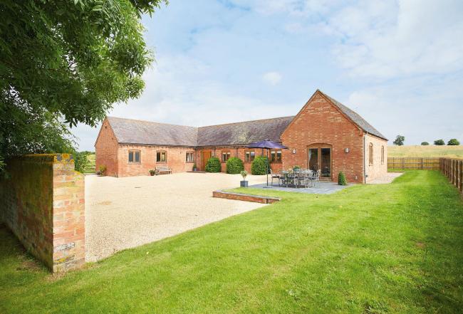 A large C-shaped single-storey rural cottage built around a courtyard.