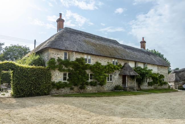 Large, thatched Dorset Farmhouse overlooking a courtyard.