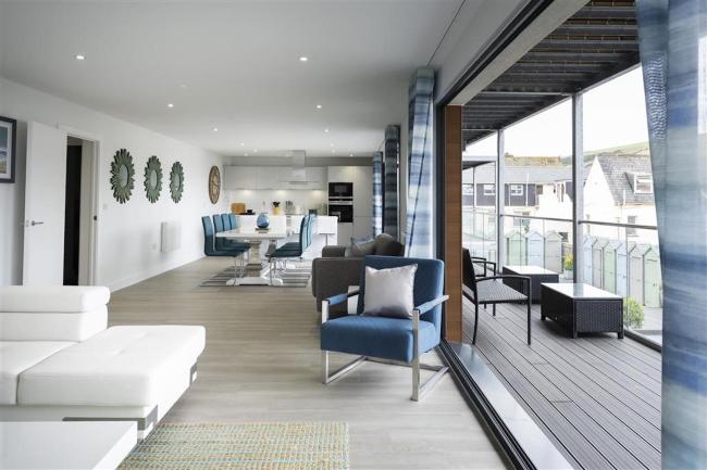 Open plan apartment interior with a full length floor-to-ceiling windows.
