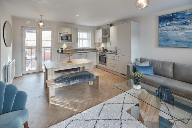 A light and spacious, lavishly furnished open-plan living area, with original artwork on the walls.