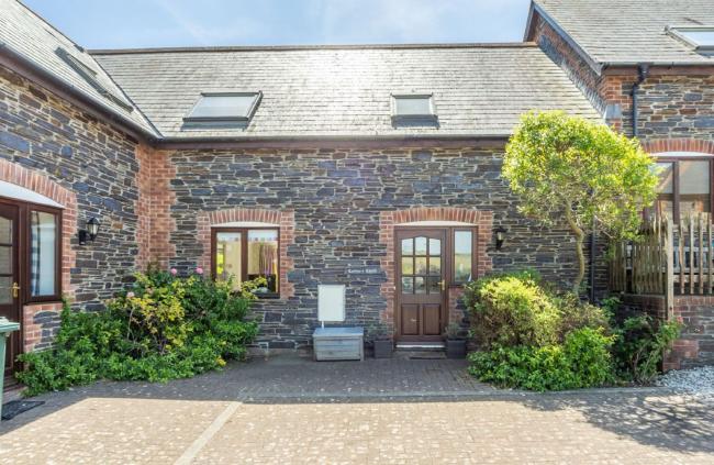A semi-detached Cornish cottage overlooks a block-paved courtyard.