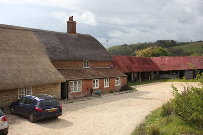 A thatched stone-built farmhouse and courtyard.